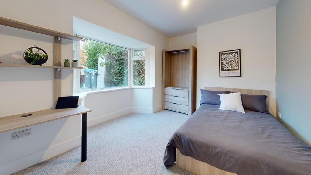 A bright and tidy double bedroom featuring a co...