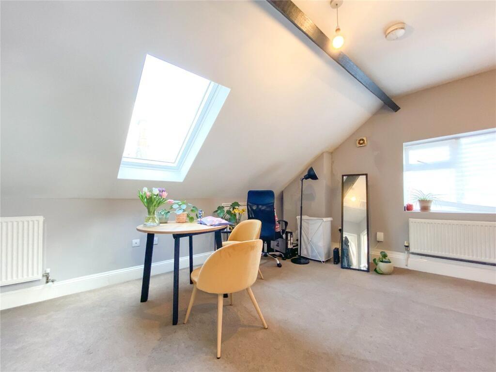 A bright and airy master bedroom featuring a sl...