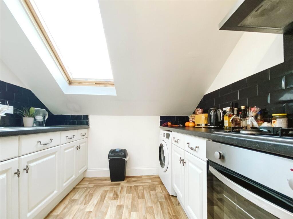 A bright and modern kitchen featuring white cab...