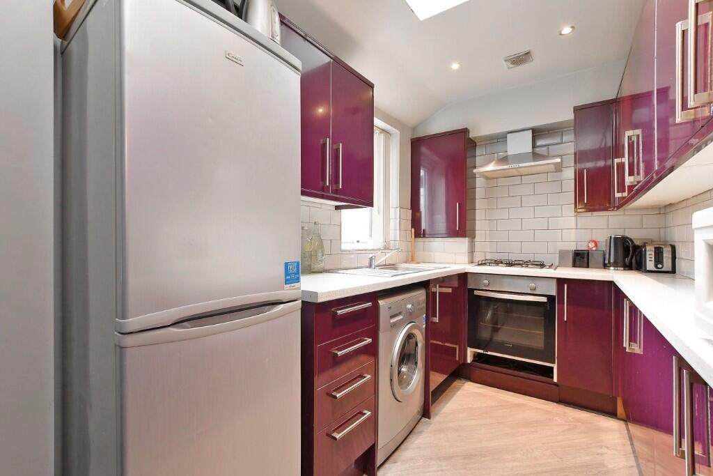 A modern kitchen with sleek purple cabinetry, w...