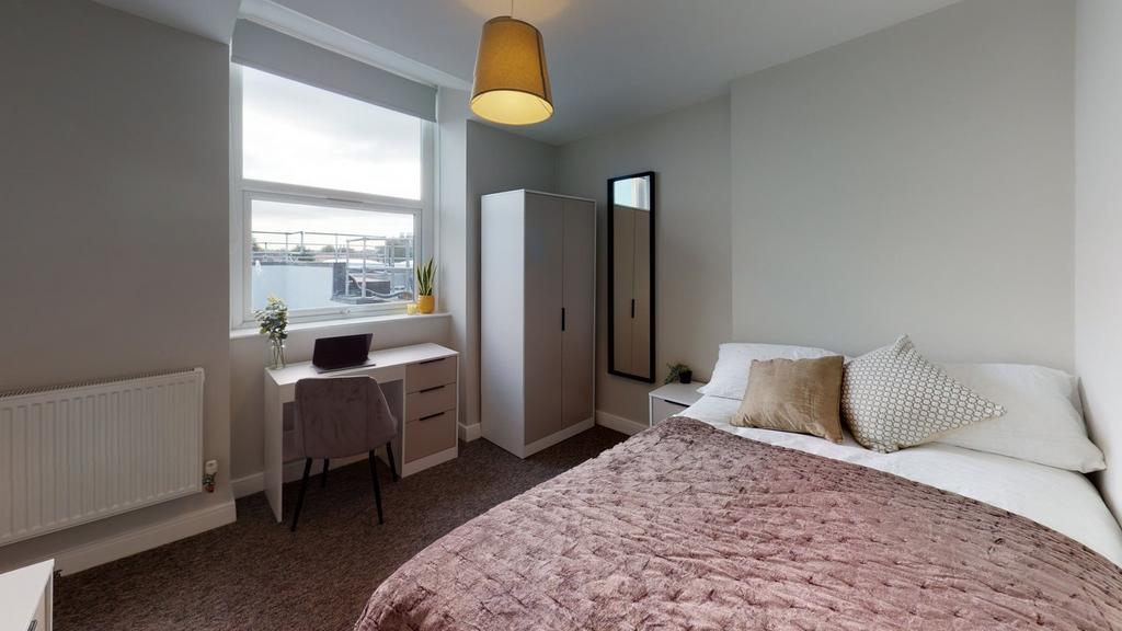 A spacious and well-lit double bedroom featurin...