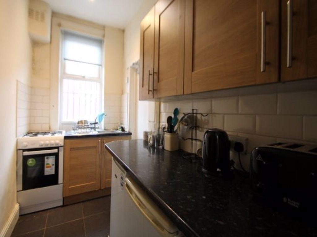 A compact and tidy kitchen featuring wooden cab...