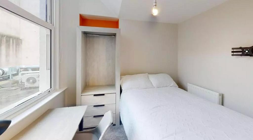 A bright and tidy double bedroom featuring mode...