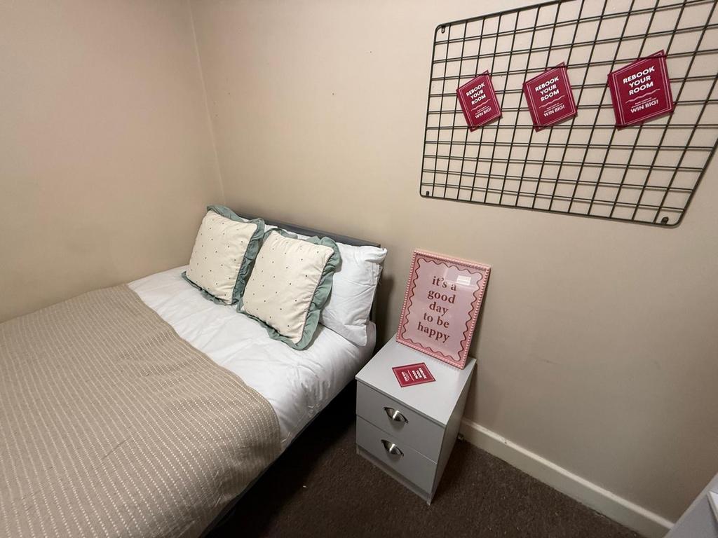 Cozy single bedroom with a neatly made bed, neu...