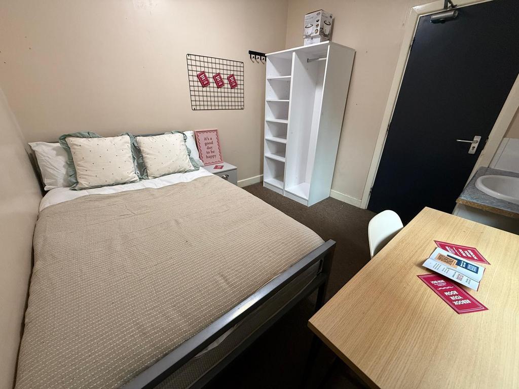 Comfortable double bedroom with a neatly made b...