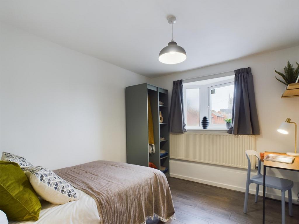 A bright and tidy double bedroom featuring a st...