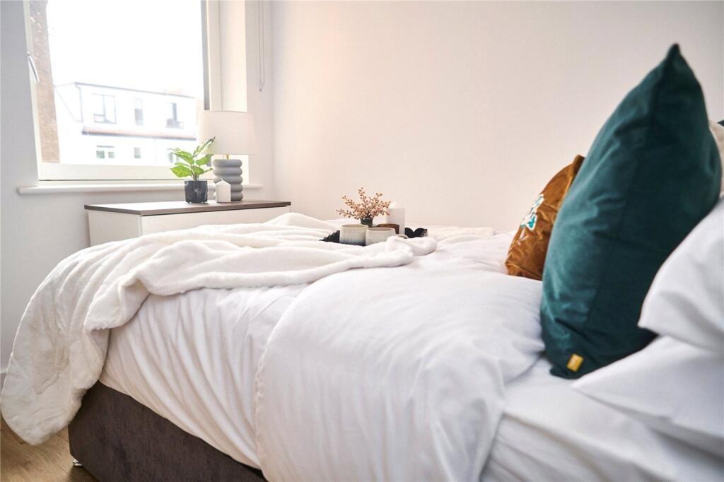 Bright and cozy bedroom featuring a neatly made...
