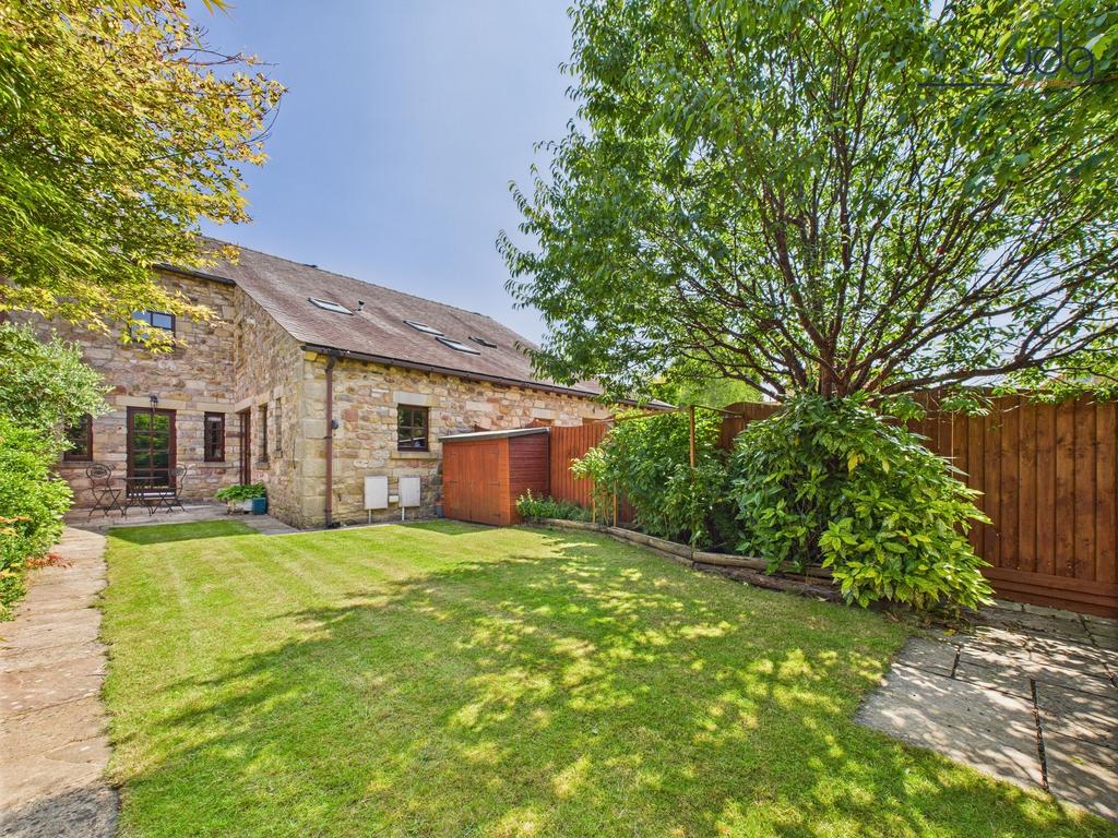 Spacious rear garden with mature plants and...