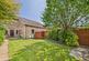 Spacious rear garden with mature plants and...
