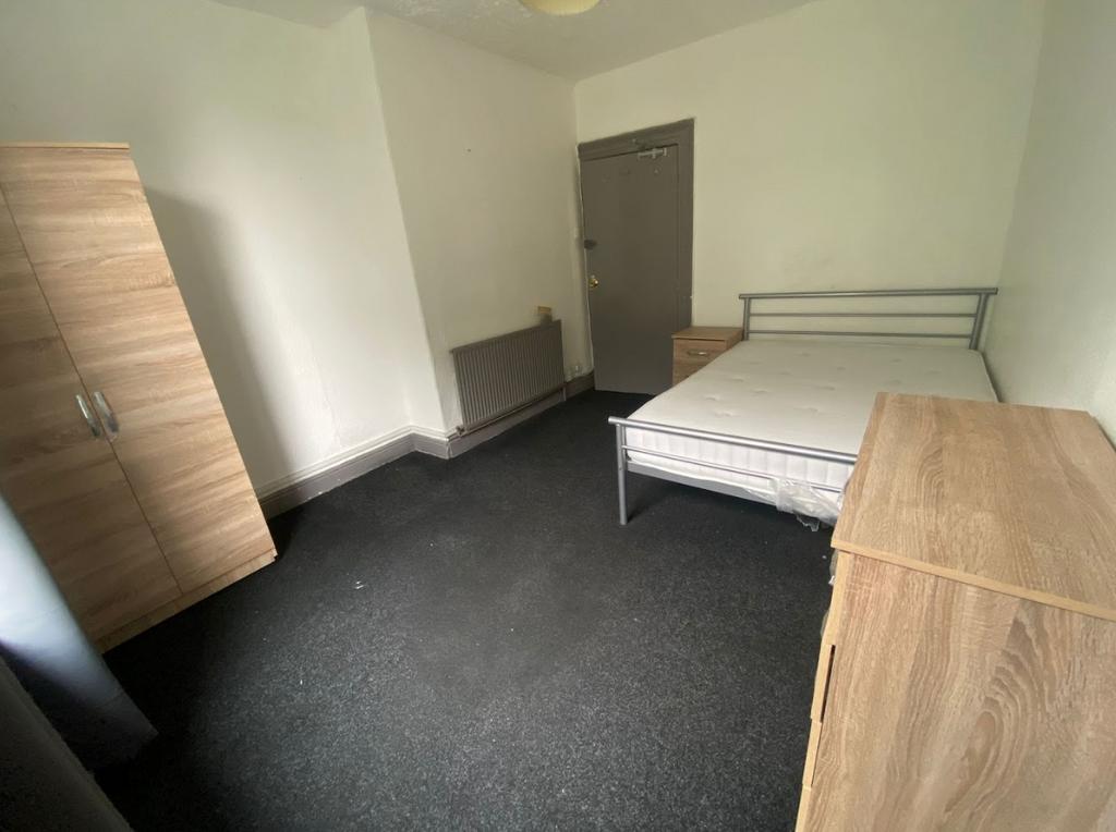 A tidy double bedroom featuring a sturdy metal ...