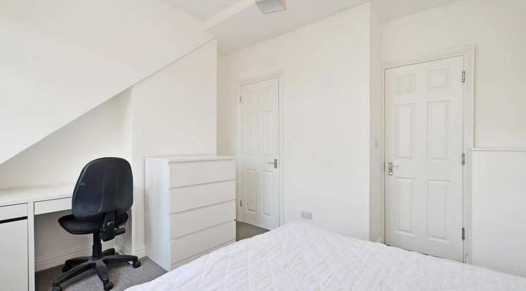 This inviting double bedroom features a cozy at...