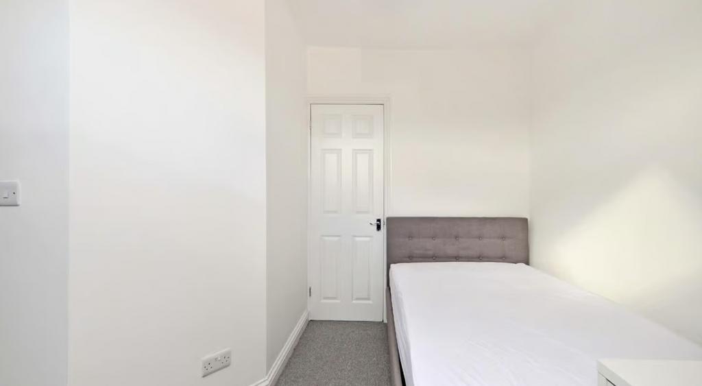 This inviting double bedroom features a neutral...