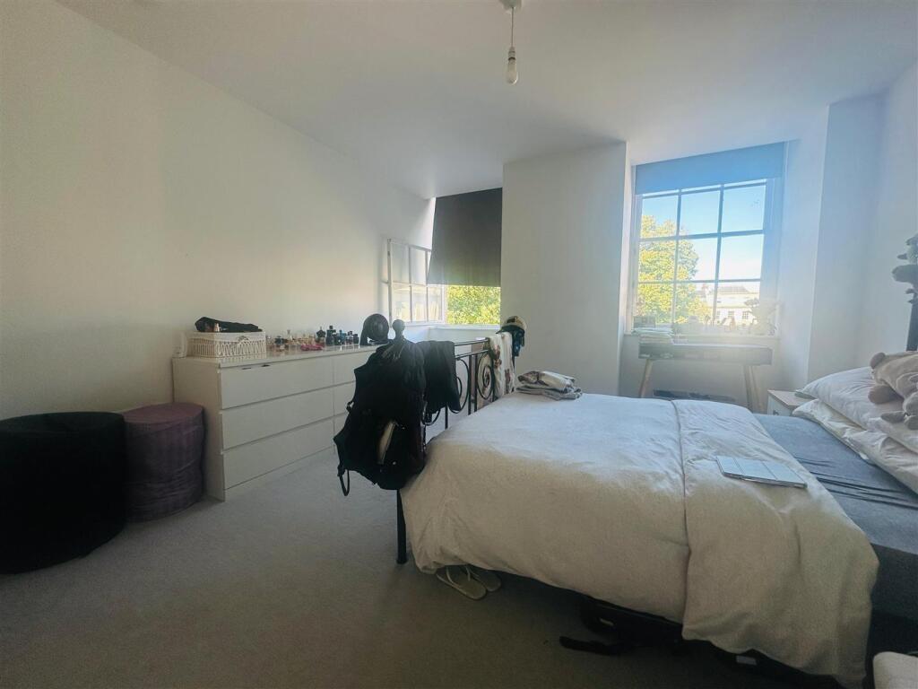 A bright and welcoming master bedroom featuring...
