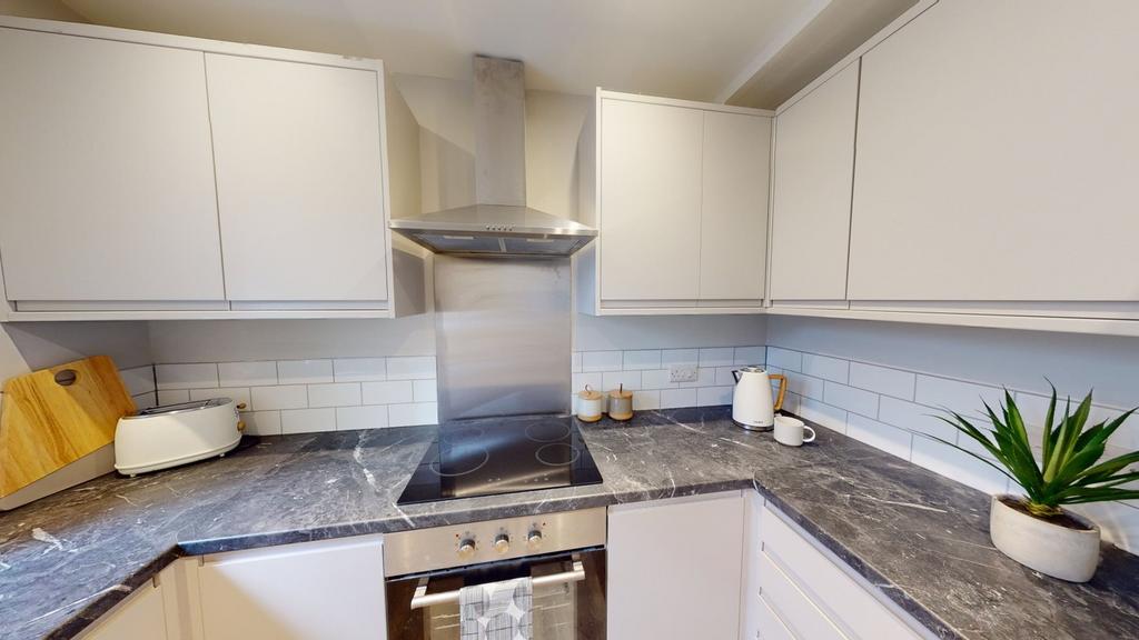 A modern and tidy kitchenette with sleek cabine...