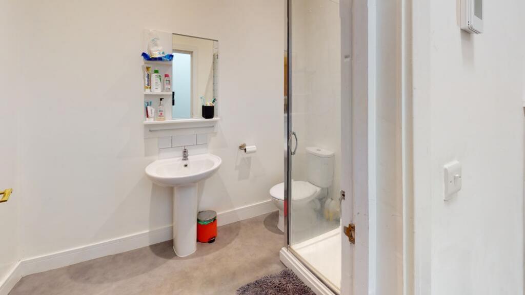 This modern bathroom features a spacious shower...