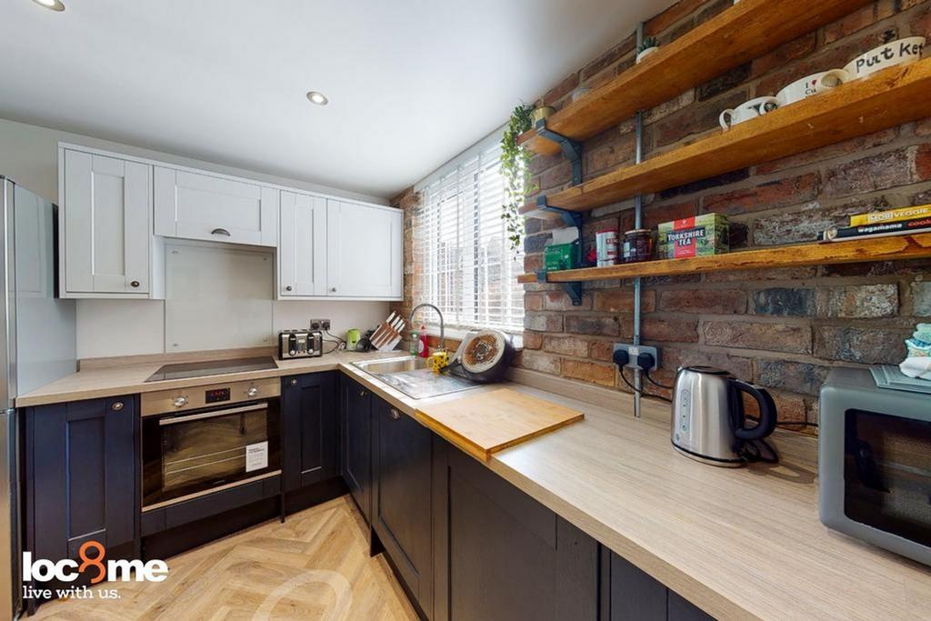 A modern and tidy kitchenette with ample storag...