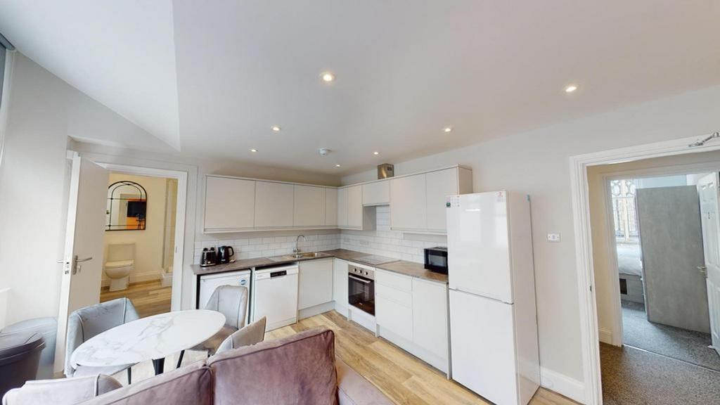A modern and clean kitchenette with ample stora...