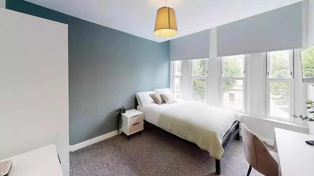 A bright and tidy double bedroom featuring larg...