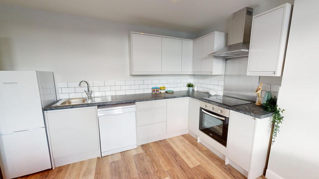 A modern and clean kitchenette with ample stora...