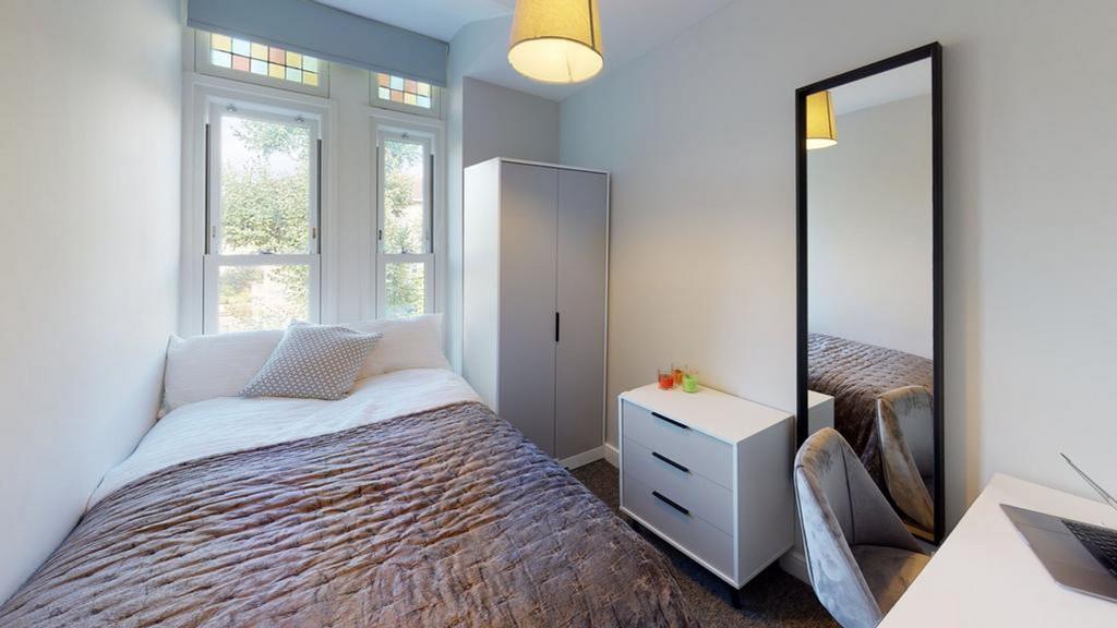 A bright and modern double bedroom featuring am...