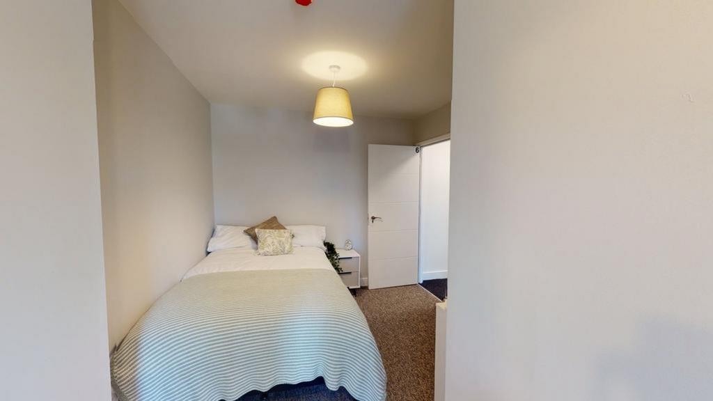 A bright and inviting double bedroom with moder...