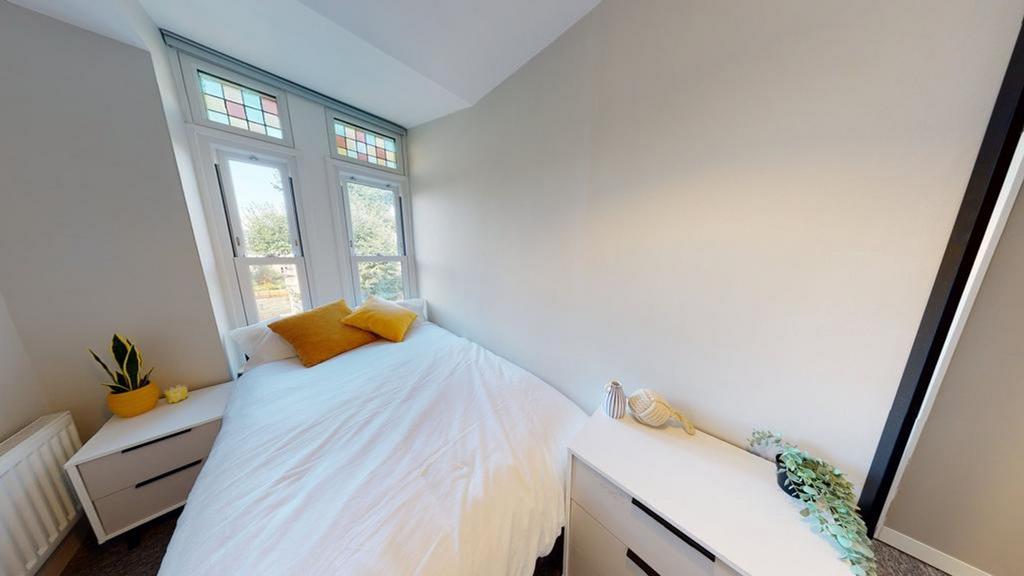 A bright and tidy double bedroom featuring larg...