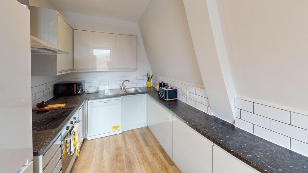 A modern kitchenette with sleek finishes and pl...
