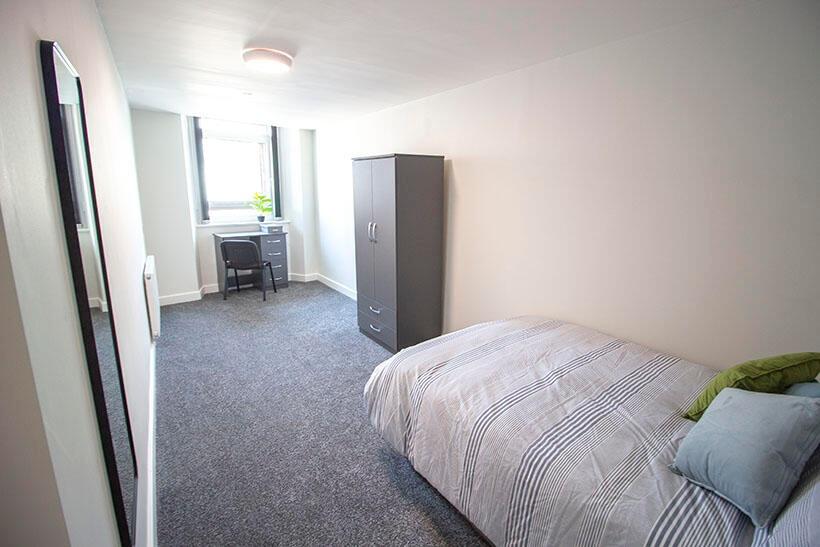 A bright and tidy single bedroom featuring a co...