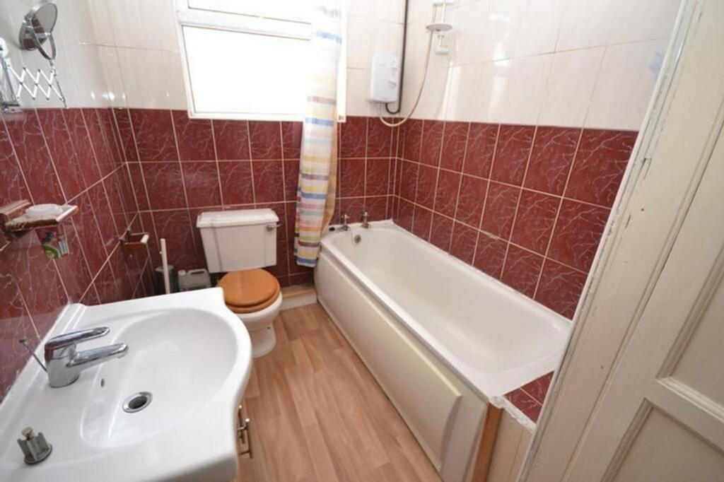 A well-maintained bathroom featuring a bathtub ...