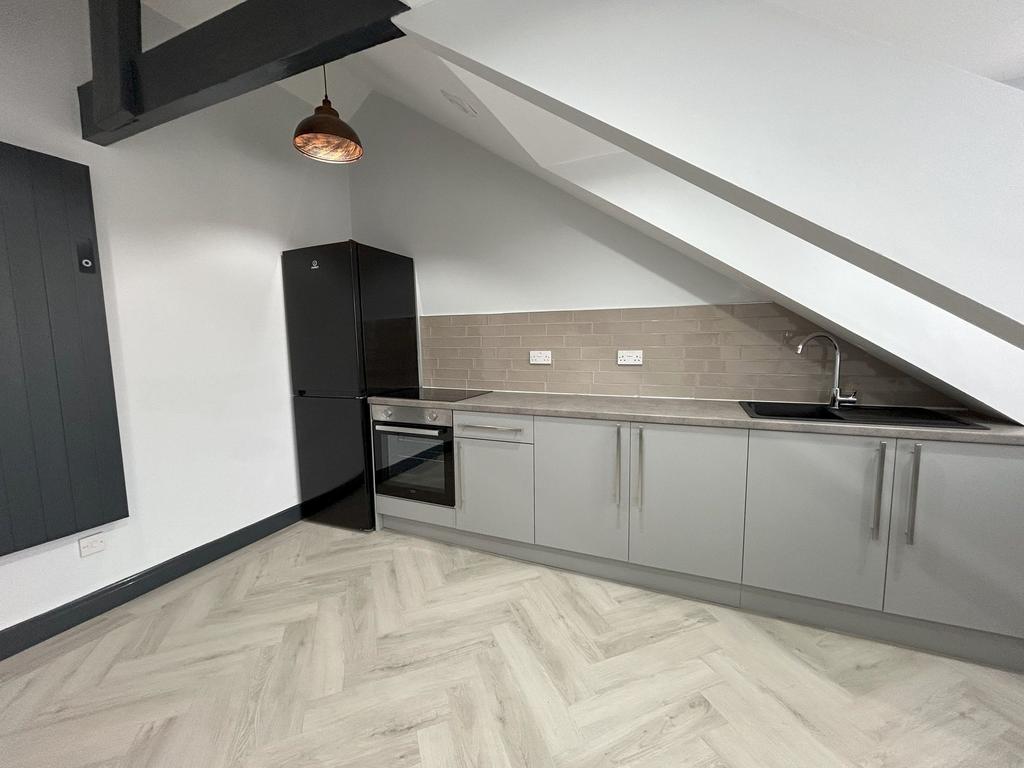 A modern kitchen with sleek grey cabinets, buil...