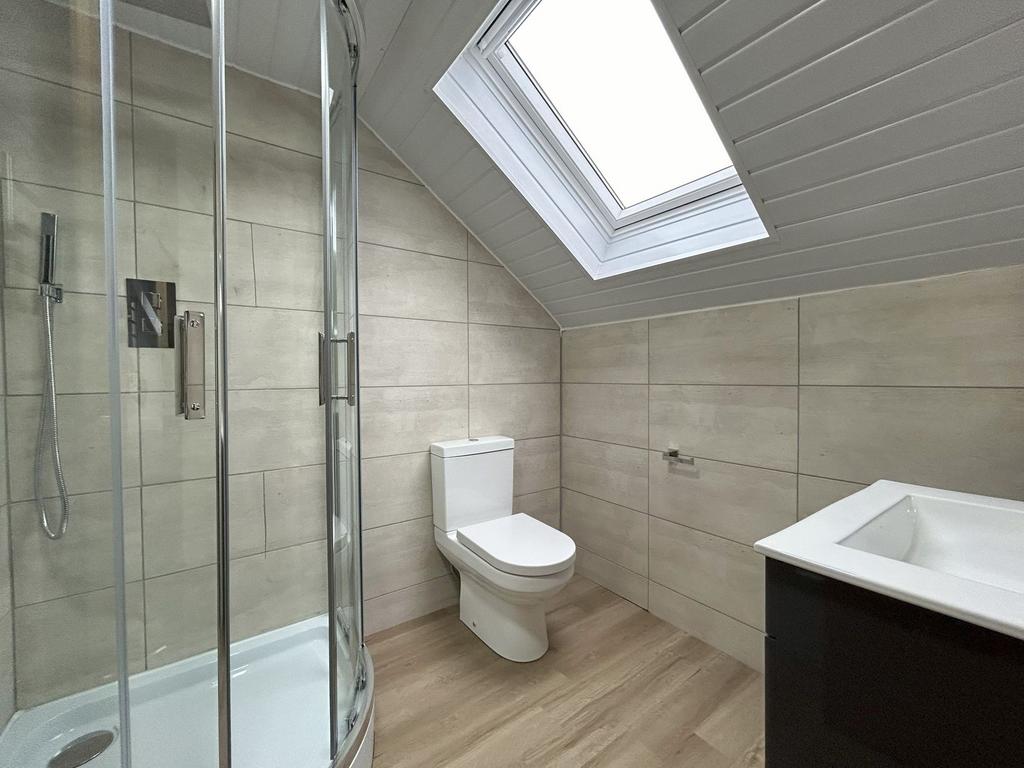 A modern bathroom featuring a corner shower wit...