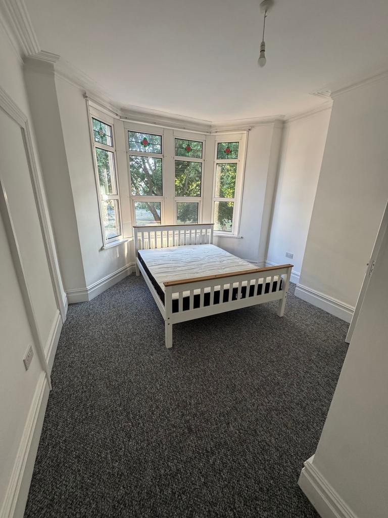 A bright double bedroom featuring a large bay w...