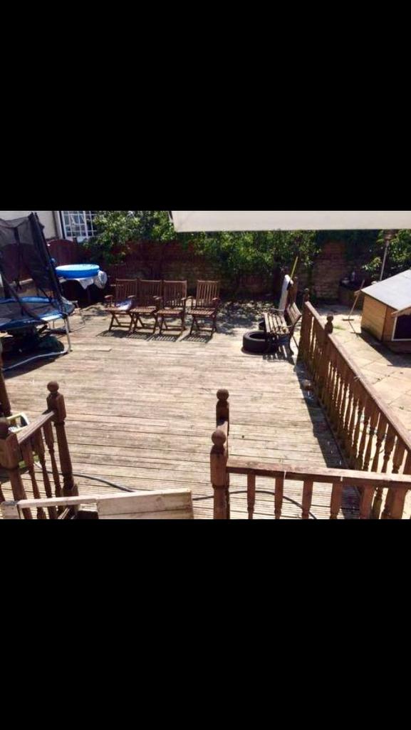 A spacious garden deck featuring wooden outdoor...