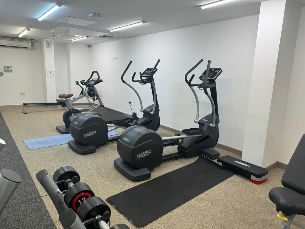 Well-equipped gym area featuring modern cardio ...
