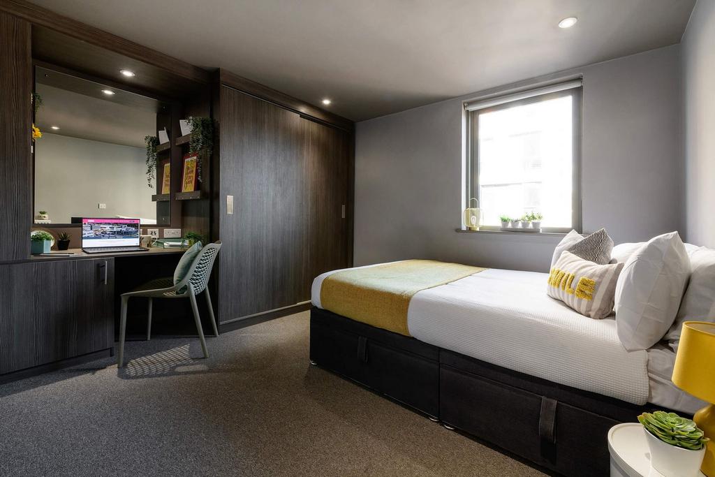 A bright and tidy single bedroom featuring a co...