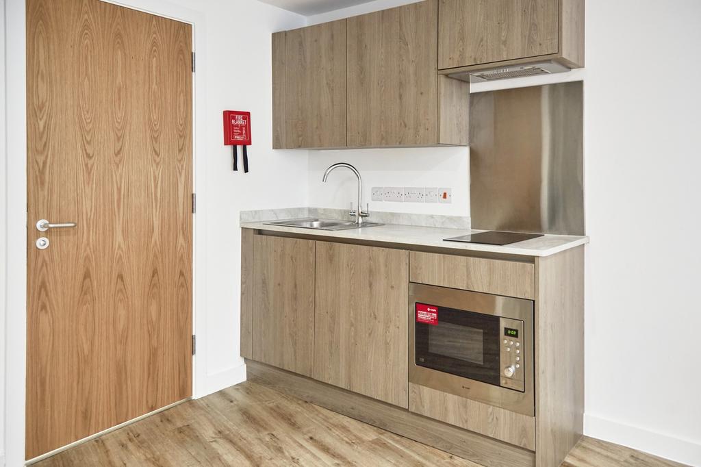 A modern kitchenette with clean finishes, perfe...