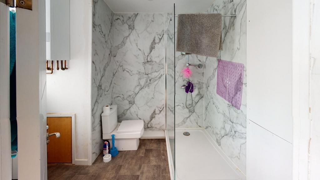 A modern bathroom featuring marble walls and a ...