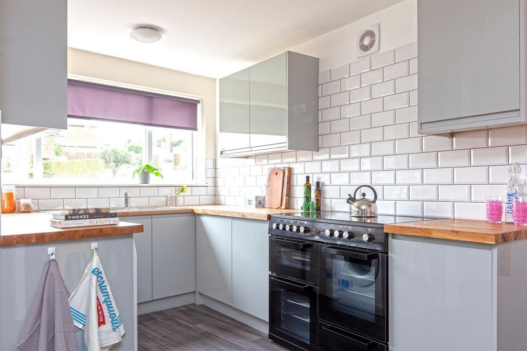 This modern kitchen features sleek cabinetry, a...