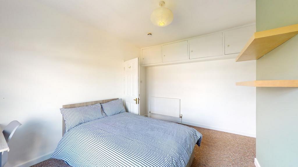 A bright and tidy double bedroom with ample spa...