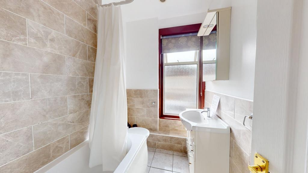 A modern and tidy bathroom featuring a bath and...