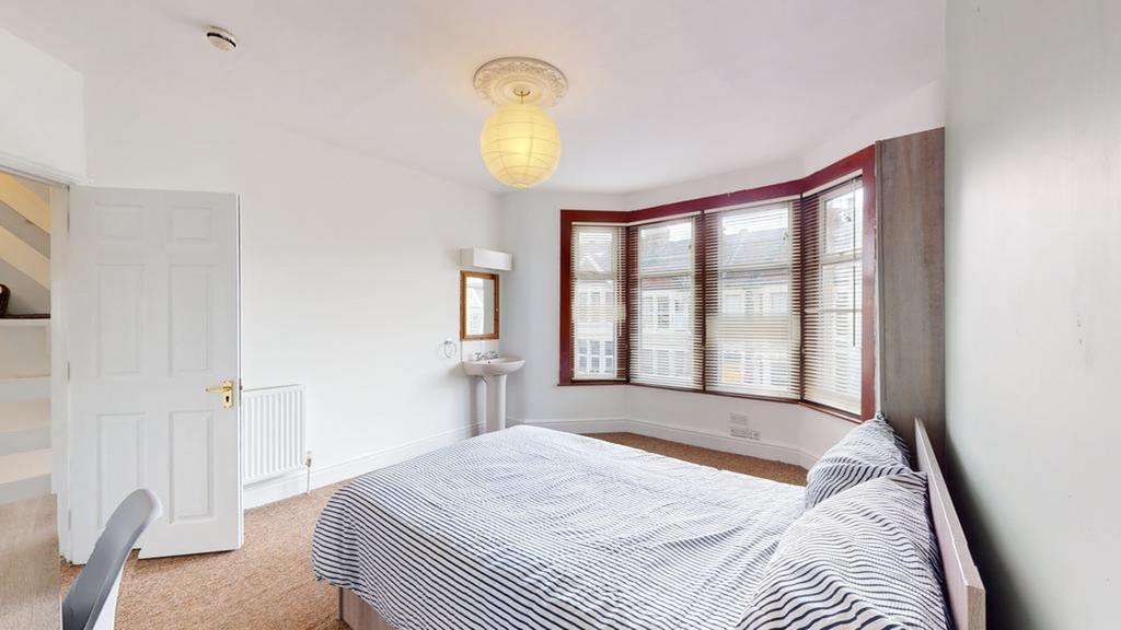 A spacious and well-lit double bedroom featurin...