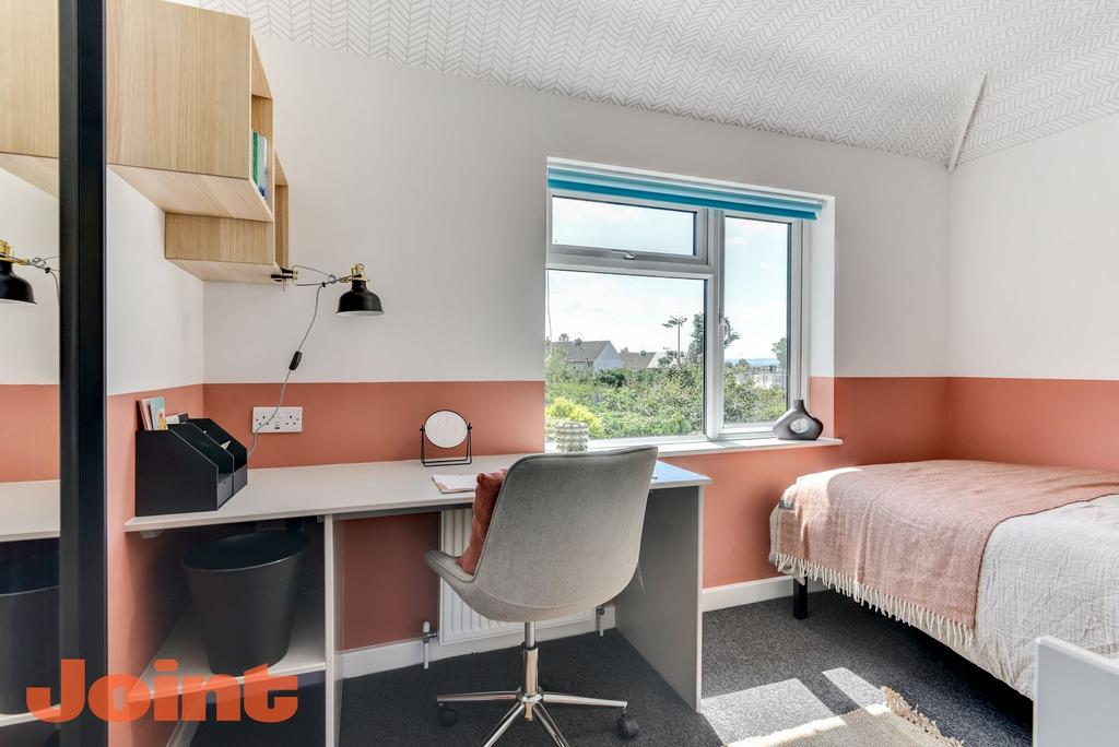 This inviting double bedroom features a cozy be...