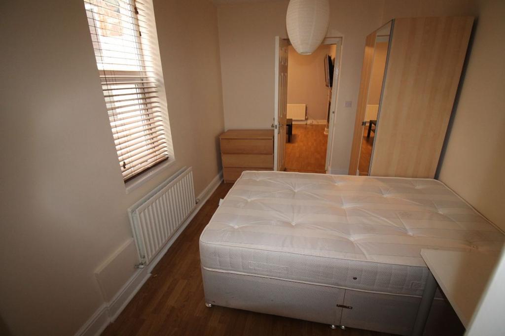 This cozy double bedroom features warm wooden f...