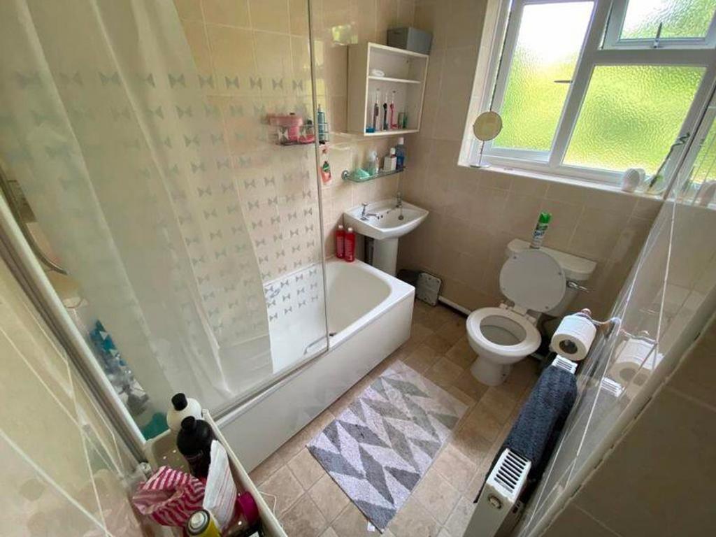 A spacious and clean bathroom featuring a bath ...