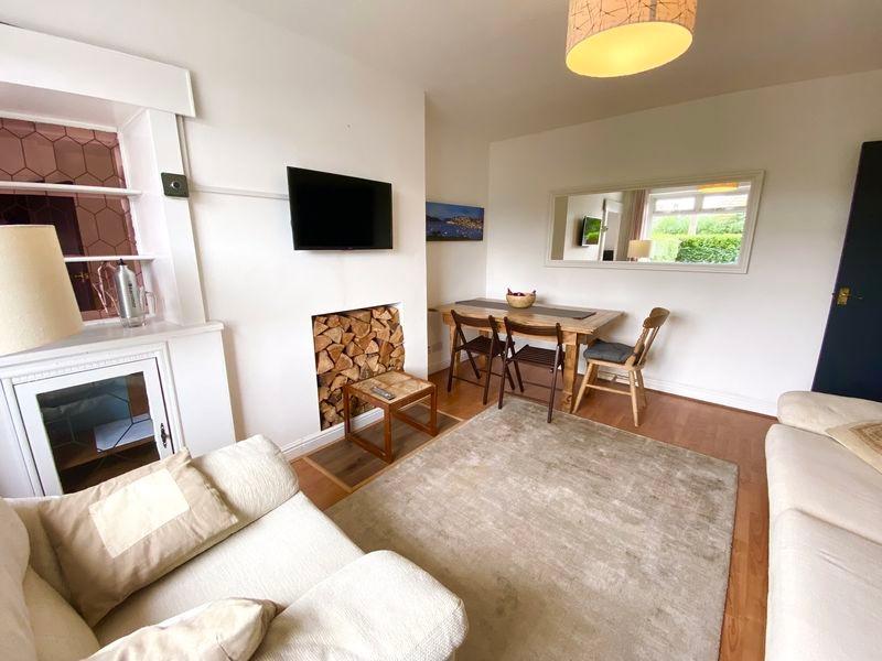 A bright and inviting living room featuring com...