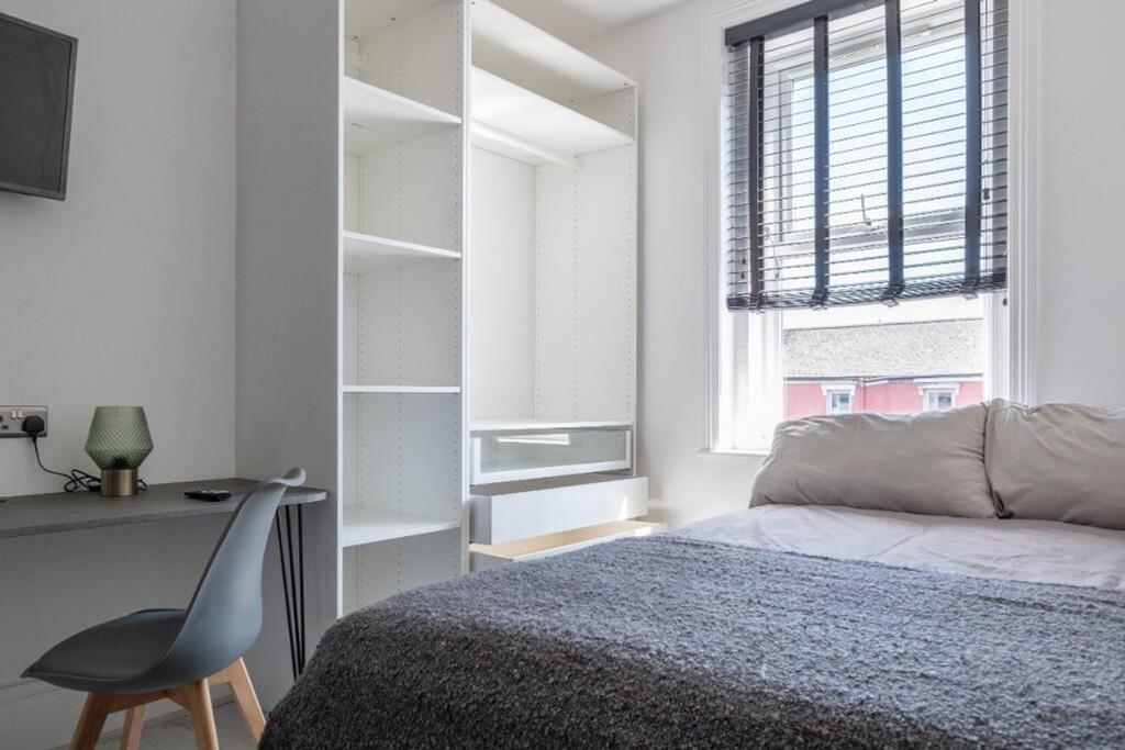 This inviting double bedroom features a cozy be...