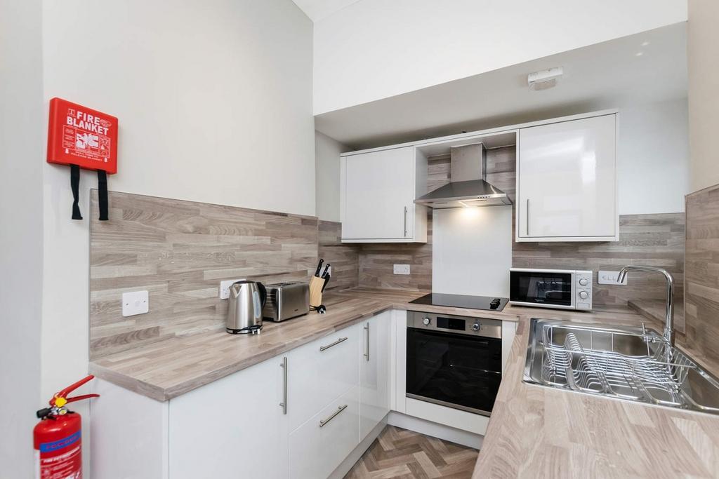 Modern kitchen with sleek white cabinets, integ...