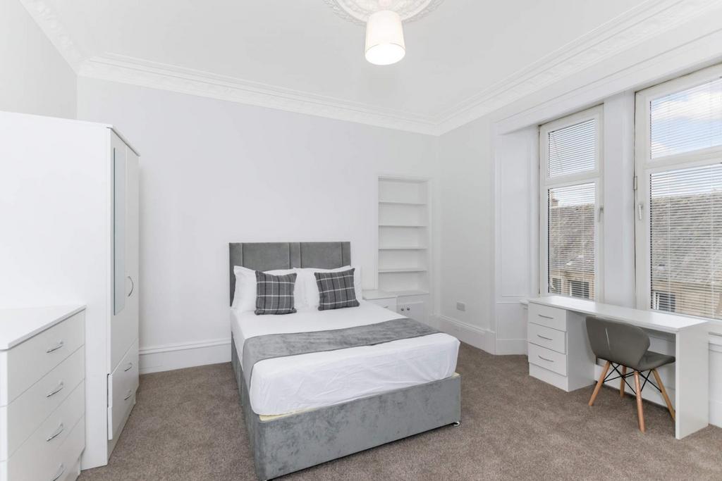 Bright and tidy double bedroom featuring a comf...