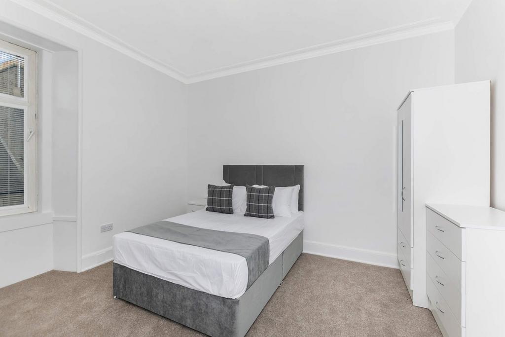 A bright and tidy double bedroom featuring a co...