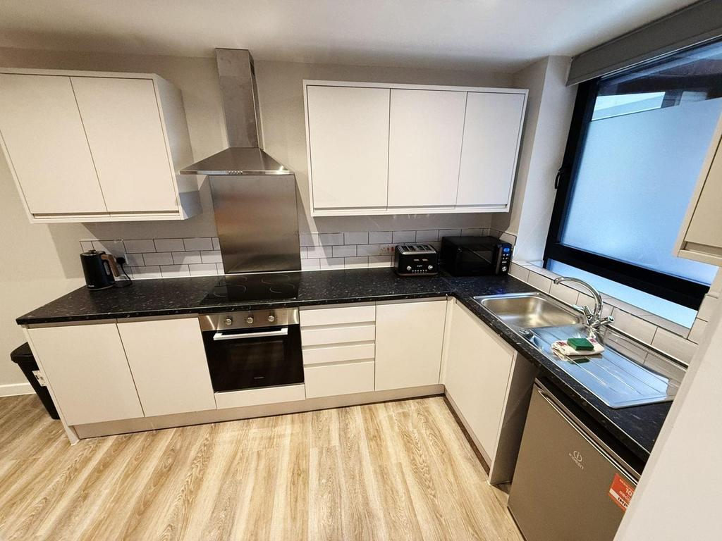 A modern and tidy kitchenette with ample storag...
